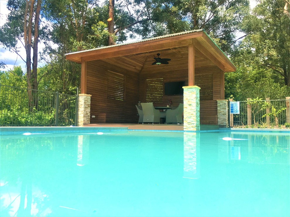 Immagine di una grande piscina monocorsia moderna personalizzata dietro casa con una dépendance a bordo piscina e pedane