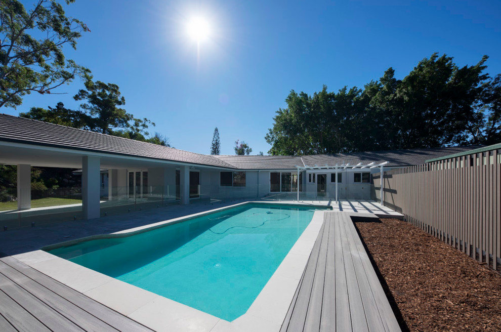 Mid-sized trendy backyard concrete paver and rectangular lap pool photo in Brisbane