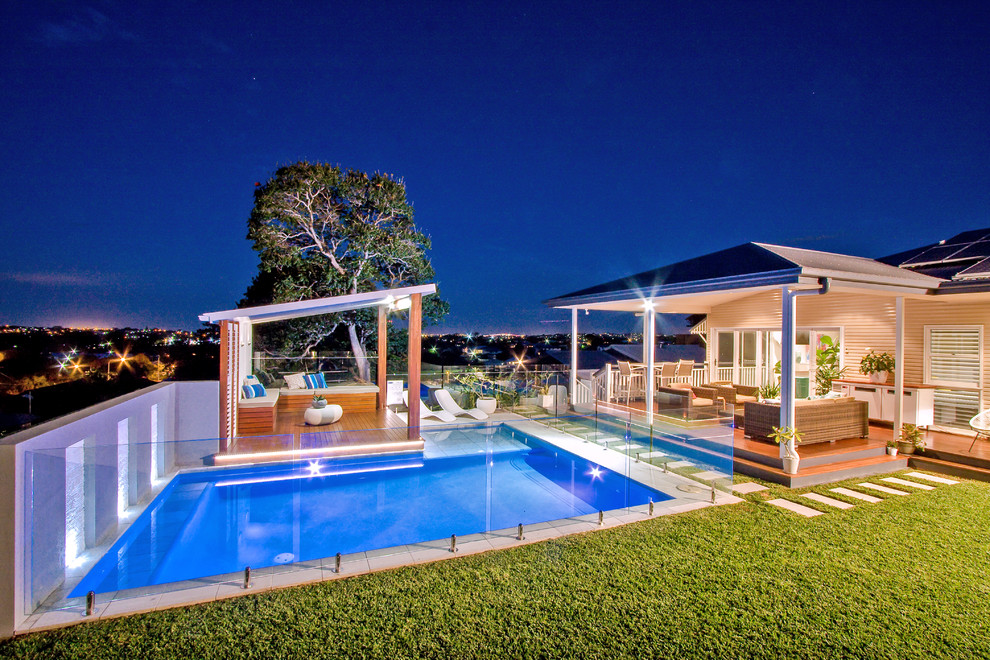 Imagen de casa de la piscina y piscina elevada minimalista de tamaño medio a medida en patio trasero con adoquines de piedra natural