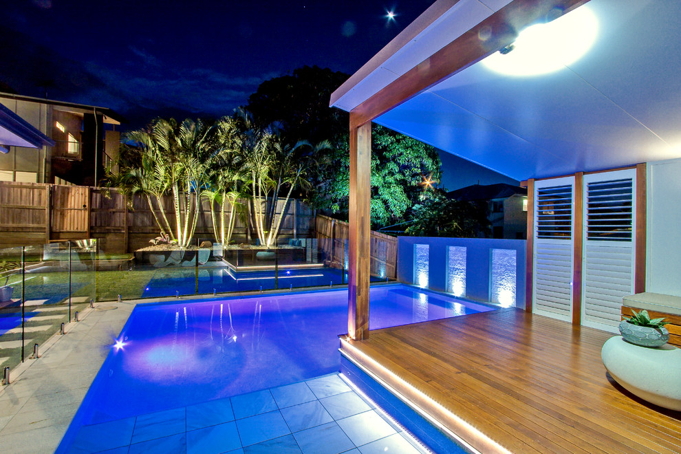 Ispirazione per una piscina moderna personalizzata di medie dimensioni e dietro casa con una dépendance a bordo piscina e pavimentazioni in pietra naturale