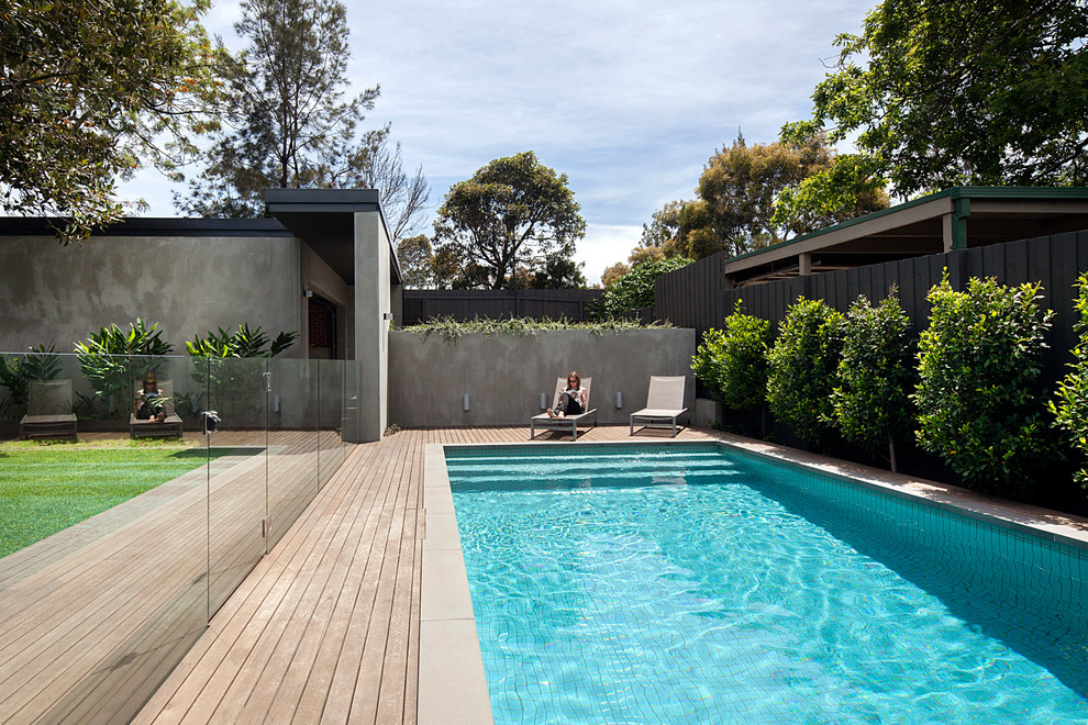 Cette image montre un couloir de nage arrière design de taille moyenne et rectangle avec une terrasse en bois.