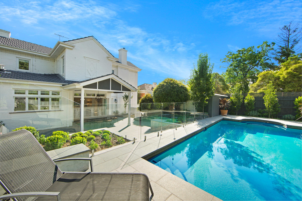Immagine di una piscina naturale vittoriana rettangolare di medie dimensioni e dietro casa con pavimentazioni in pietra naturale