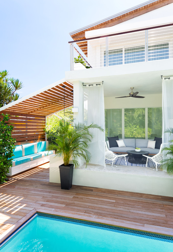 Imagen de casa de la piscina y piscina alargada marinera de tamaño medio rectangular en patio trasero con entablado