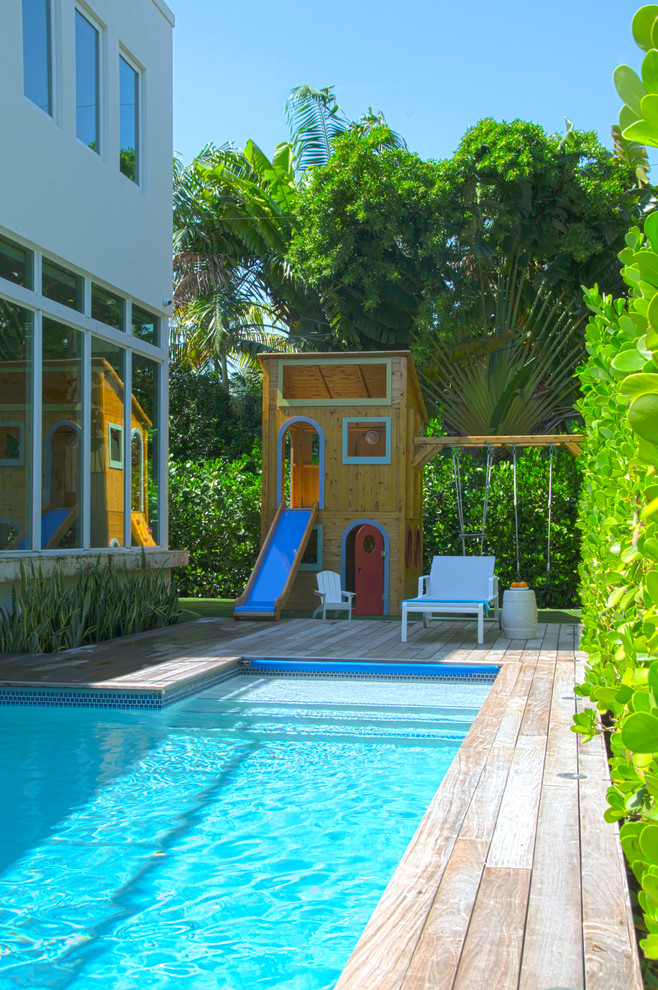 Inspiration for a mid-sized coastal backyard rectangular lap pool house remodel in Miami with decking