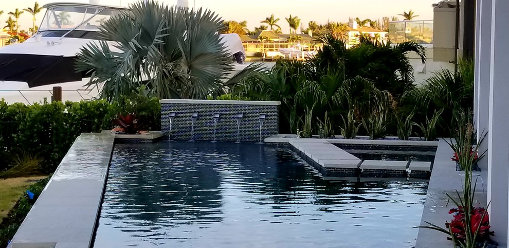 Foto de piscinas y jacuzzis retro de tamaño medio a medida en patio trasero con losas de hormigón