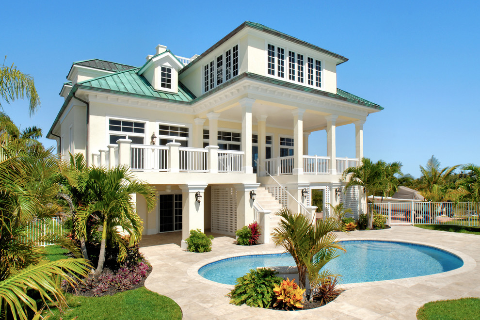 Foto di una grande piscina tropicale a "C" dietro casa con fontane