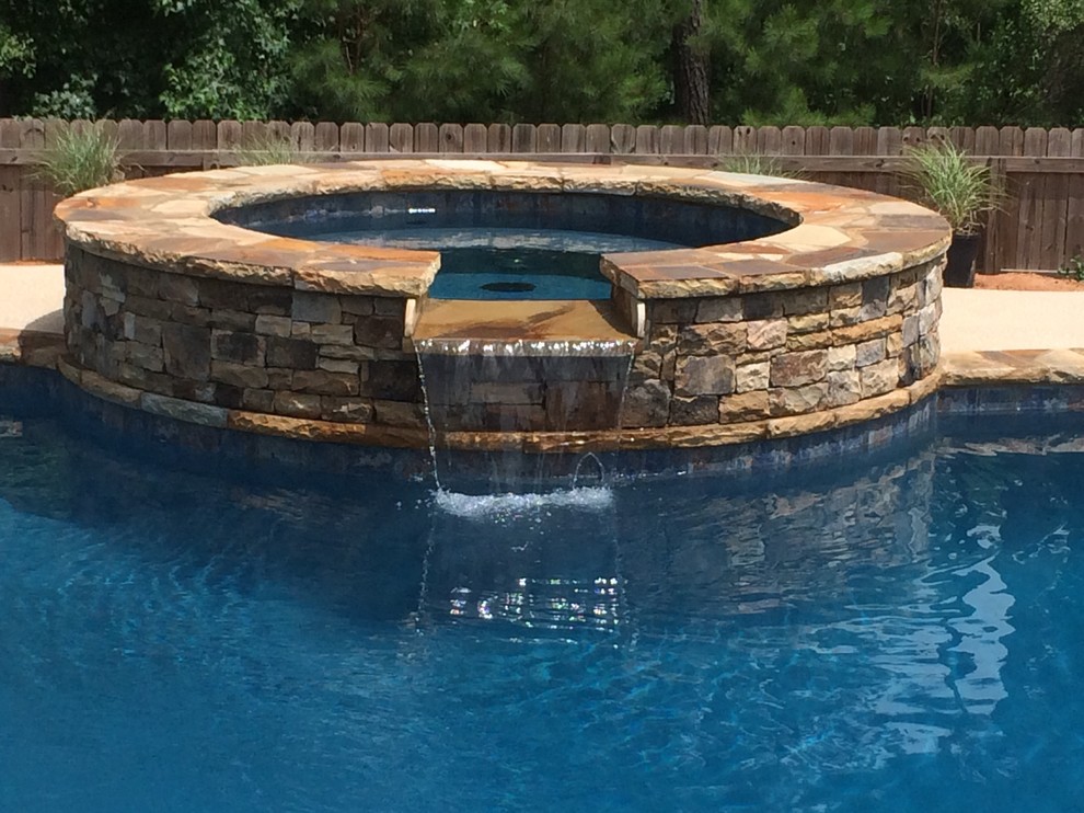 Foto de piscinas y jacuzzis de estilo americano de tamaño medio tipo riñón en patio trasero con adoquines de piedra natural