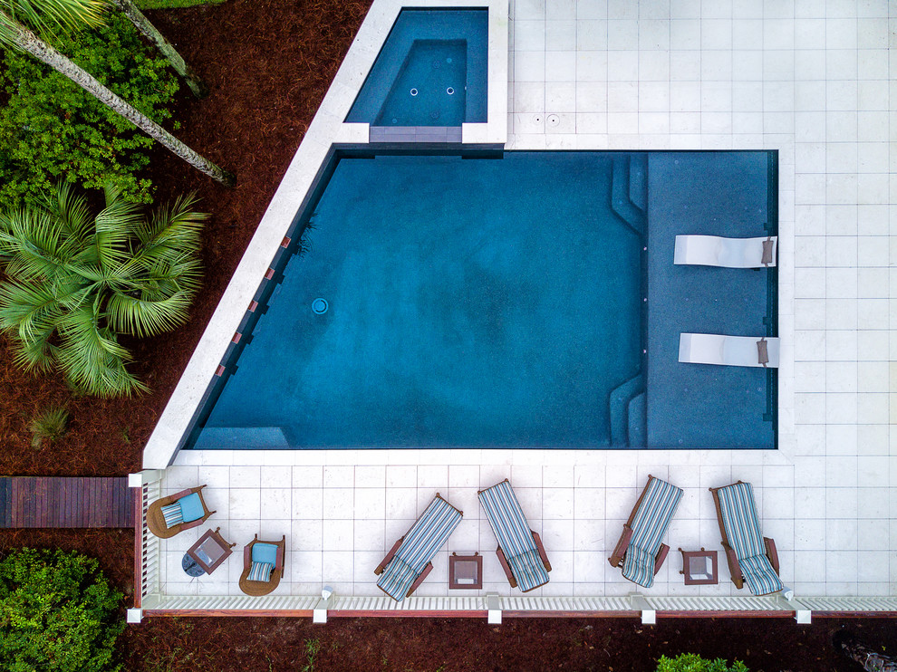 Esempio di una grande piscina fuori terra minimal personalizzata dietro casa con una dépendance a bordo piscina e pavimentazioni in pietra naturale