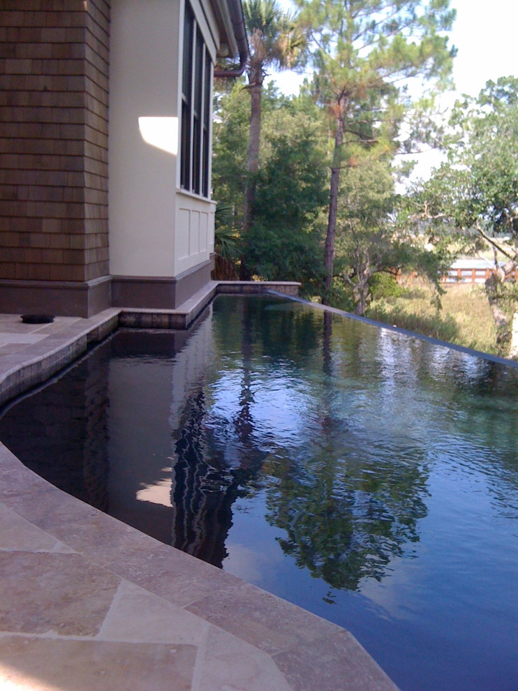 Cette image montre une piscine à débordement et arrière traditionnelle de taille moyenne et sur mesure avec du carrelage.