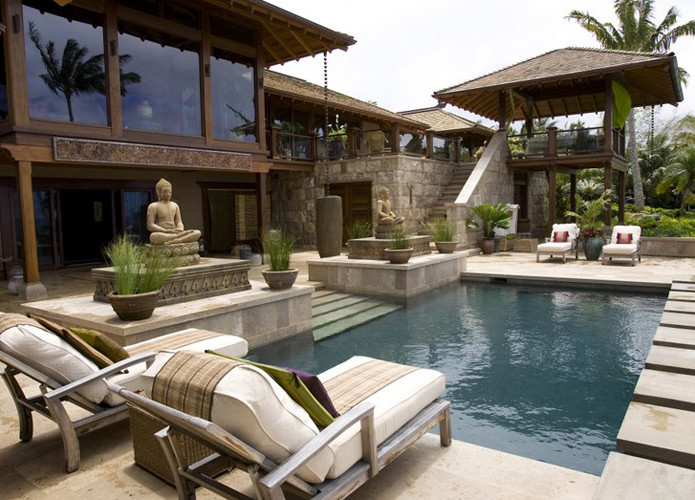 Foto di una piscina tropicale rettangolare di medie dimensioni e dietro casa con pavimentazioni in cemento