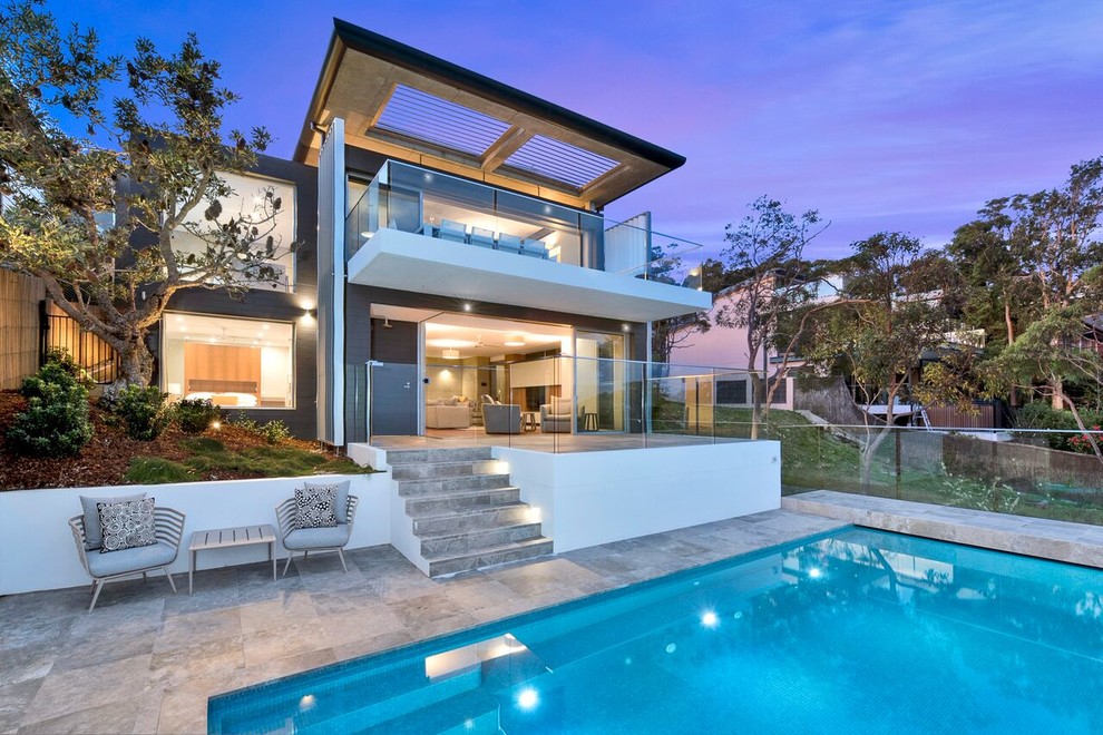 Photo of a large contemporary back rectangular lengths swimming pool in Sydney with concrete slabs.