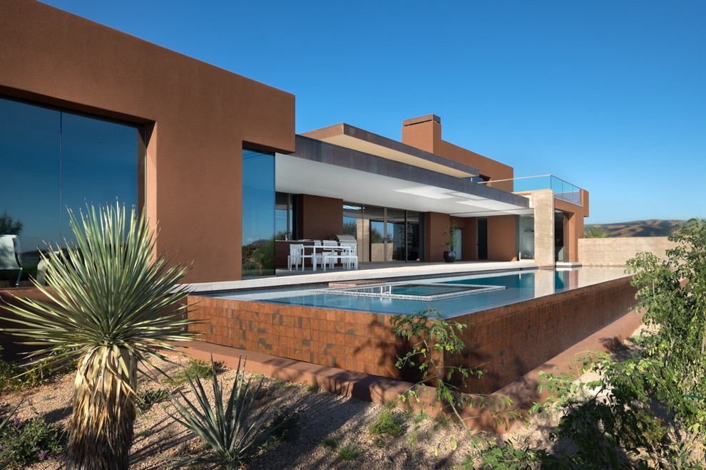 Ejemplo de piscinas y jacuzzis alargados de estilo americano de tamaño medio rectangulares en patio trasero con suelo de baldosas