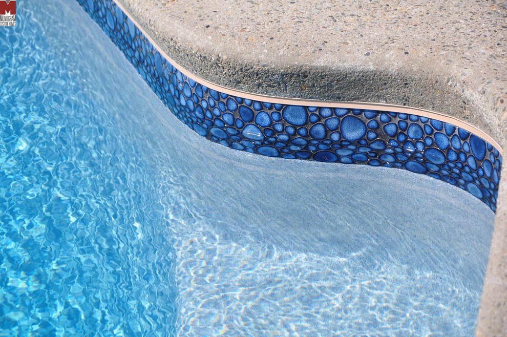 На фото: бассейн в форме фасоли на заднем дворе в современном стиле
