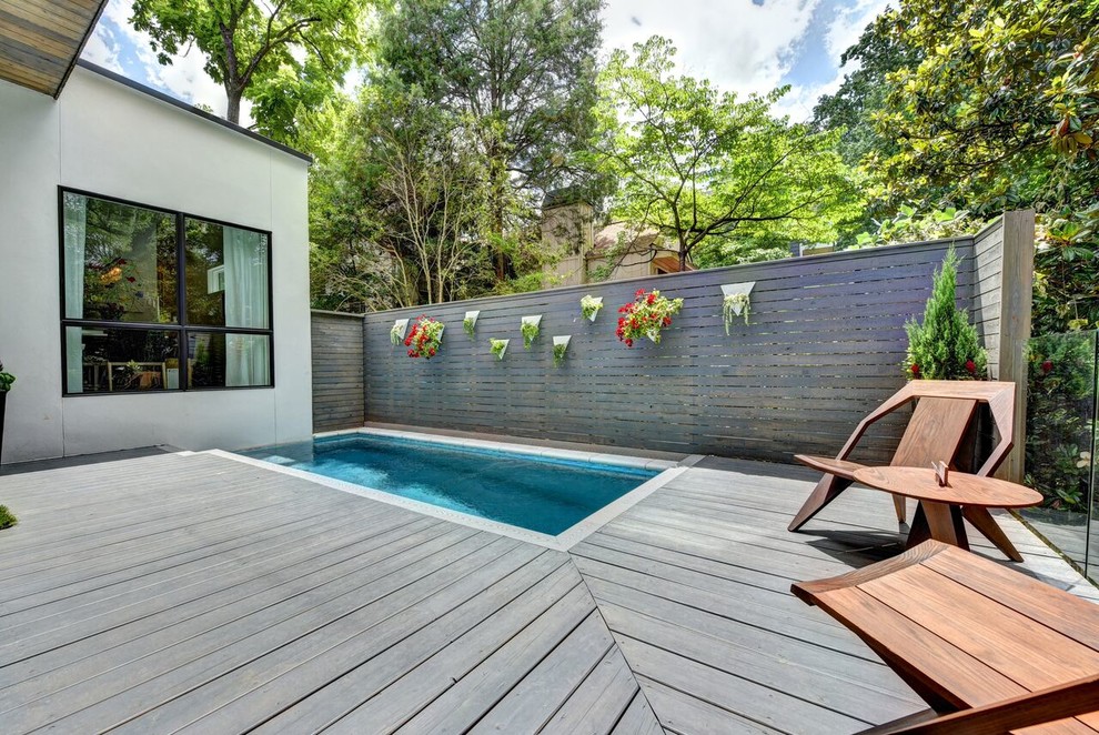 Imagen de piscina alargada moderna de tamaño medio rectangular en patio lateral con entablado