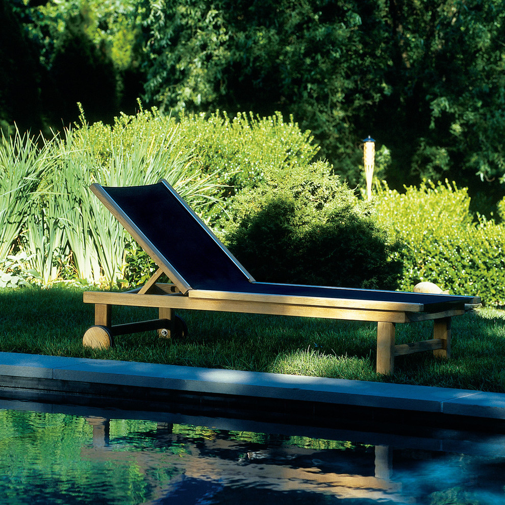 Modelo de piscina natural clásica renovada pequeña rectangular en patio trasero con adoquines de piedra natural