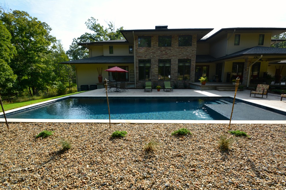 Стильный дизайн: большой прямоугольный, спортивный бассейн на заднем дворе в современном стиле с покрытием из гравия - последний тренд
