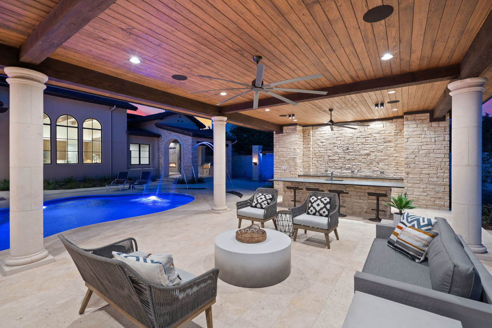 Foto di un'ampia piscina chic personalizzata dietro casa con una dépendance a bordo piscina e pavimentazioni in pietra naturale