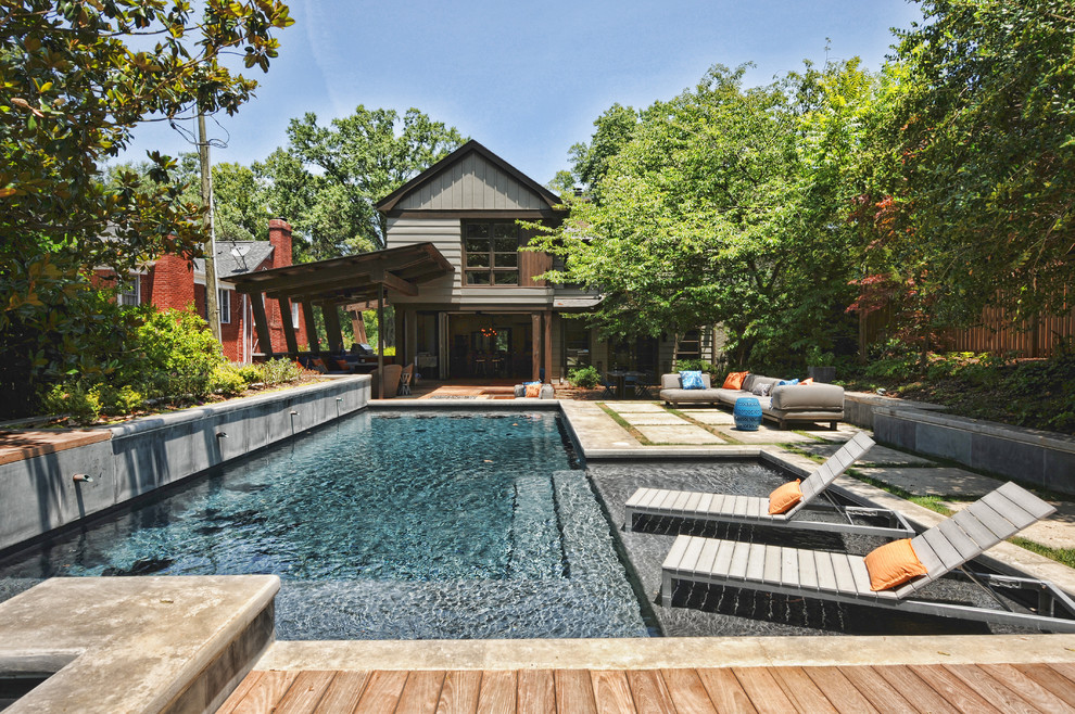 Diseño de piscina alargada rústica en forma de L en patio trasero con entablado