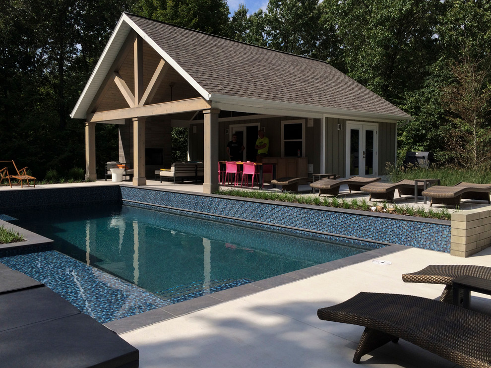 Foto di un'ampia piscina monocorsia design personalizzata dietro casa con una dépendance a bordo piscina e piastrelle