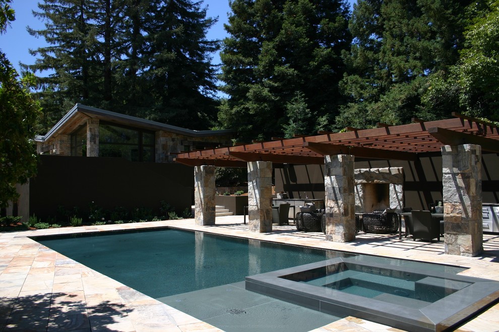 Foto de casa de la piscina y piscina infinita contemporánea grande rectangular en patio trasero con adoquines de piedra natural