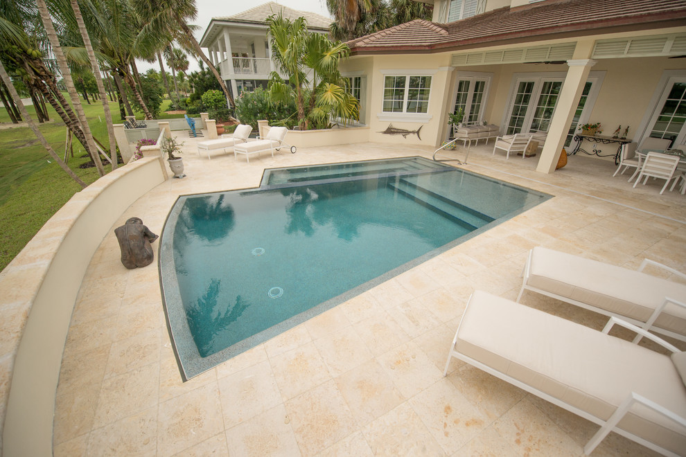 Exemple d'une piscine à débordement et arrière moderne de taille moyenne et sur mesure avec des pavés en pierre naturelle.