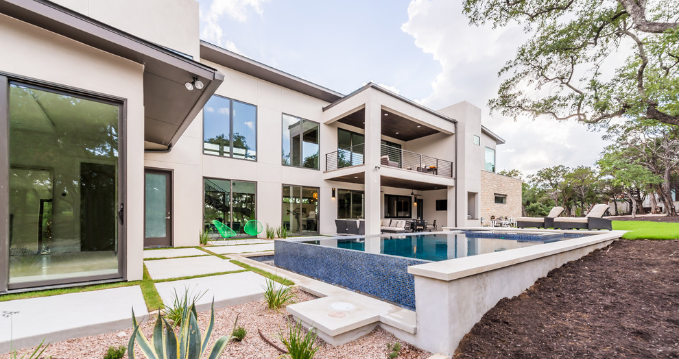 Großer Moderner Pool hinter dem Haus in rechteckiger Form mit Betonplatten in Austin