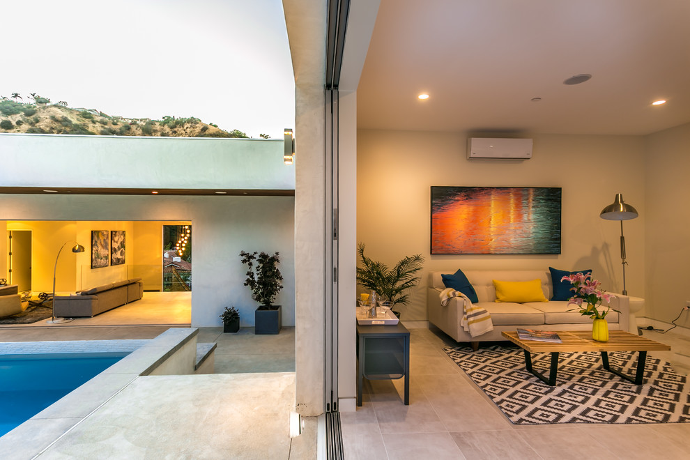 Imagen de casa de la piscina y piscina alargada minimalista rectangular en patio trasero con suelo de baldosas