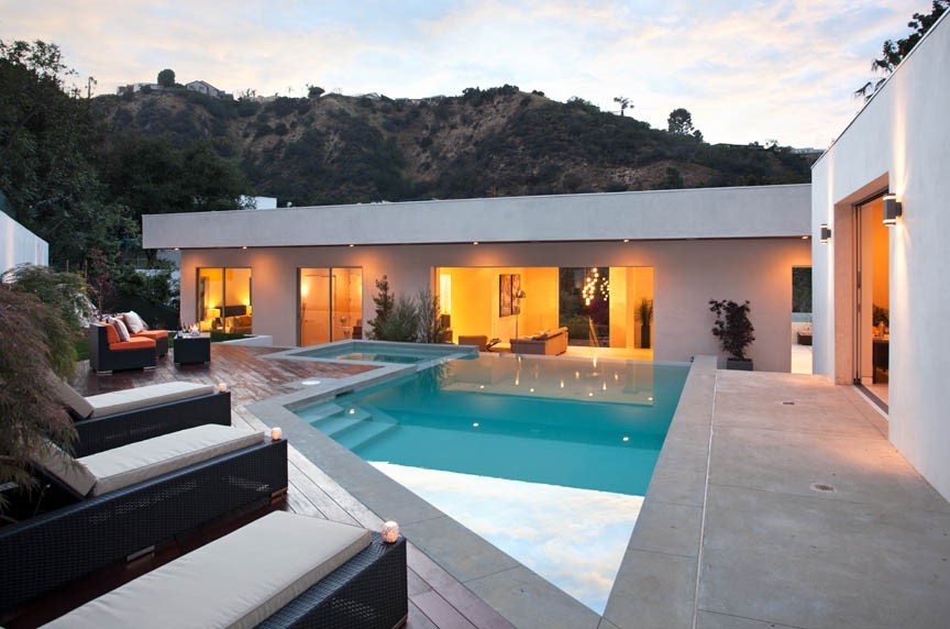 Diseño de casa de la piscina y piscina infinita actual de tamaño medio a medida en patio trasero con suelo de baldosas