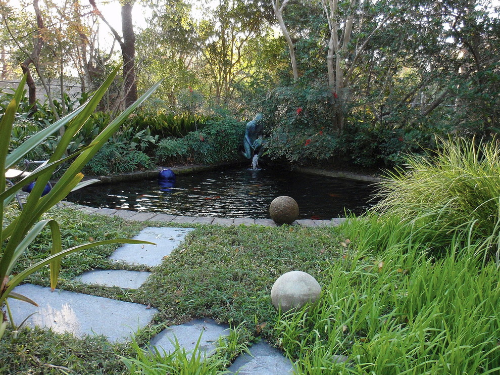 Inspiration pour un petit jardin arrière traditionnel avec un point d'eau et des pavés en pierre naturelle.