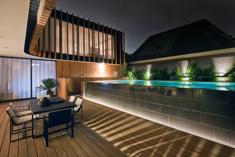 Aménagement d'une grande piscine hors-sol contemporaine rectangle avec une terrasse en bois.