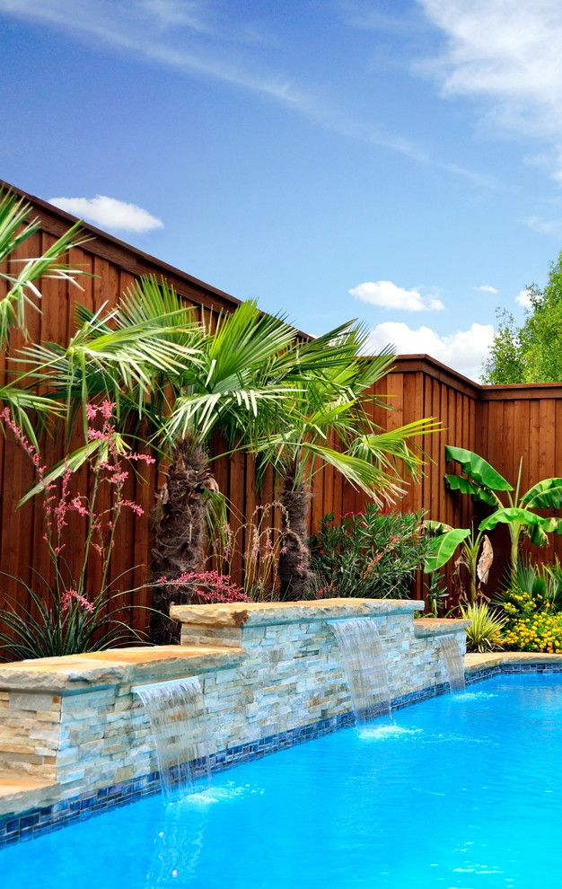 Example of a large trendy backyard rectangular natural pool fountain design in Dallas with decking