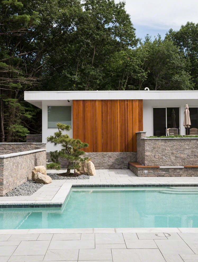 Inspiration för mellanstora moderna anpassad pooler på baksidan av huset, med poolhus och kakelplattor