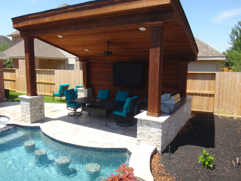 Imagen de piscinas y jacuzzis alargados clásicos renovados grandes a medida en patio trasero con adoquines de piedra natural