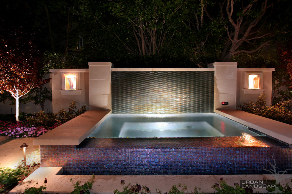 На фото: большой прямоугольный бассейн-инфинити на заднем дворе в современном стиле с фонтаном и покрытием из плитки