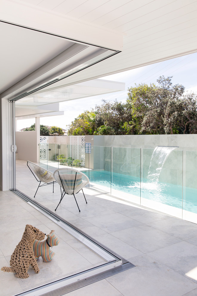 Photo of a medium sized beach style courtyard rectangular lengths swimming pool in Central Coast with a water feature and concrete slabs.