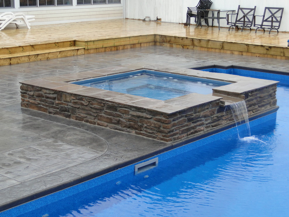 Imagen de piscinas y jacuzzis modernos grandes en forma de L en patio trasero con suelo de hormigón estampado