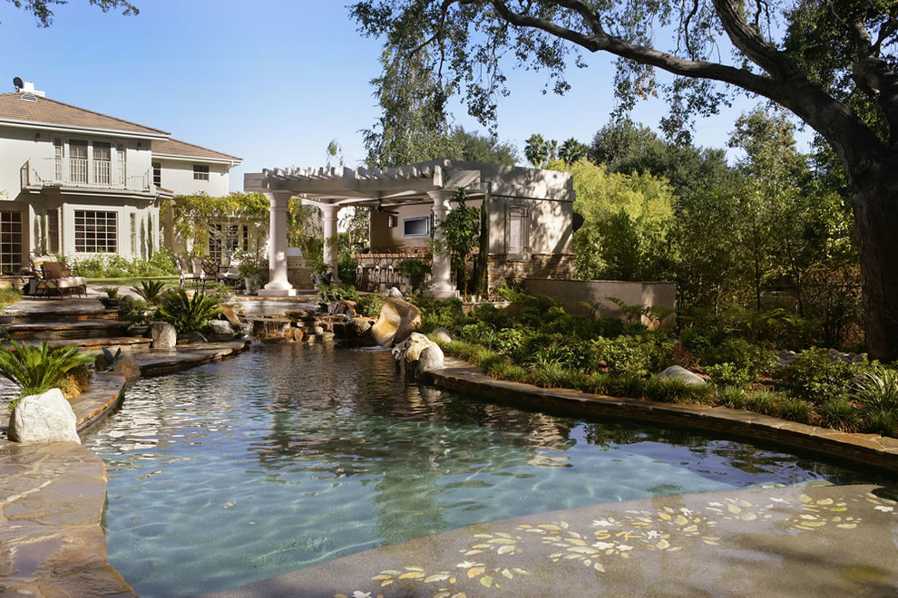 Mittelgroßer Uriger Schwimmteich hinter dem Haus in individueller Form mit Wasserspiel und Natursteinplatten in Los Angeles