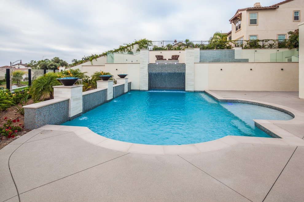 Medium sized modern back rectangular swimming pool in San Diego with a water feature and concrete slabs.