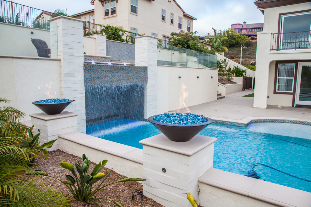 Inspiration for a medium sized modern back rectangular swimming pool in San Diego with a water feature and concrete slabs.