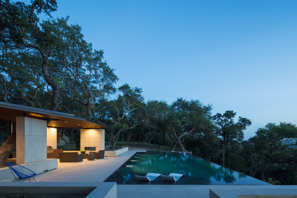Идея дизайна: большой прямоугольный бассейн-инфинити на заднем дворе в современном стиле с джакузи и покрытием из каменной брусчатки
