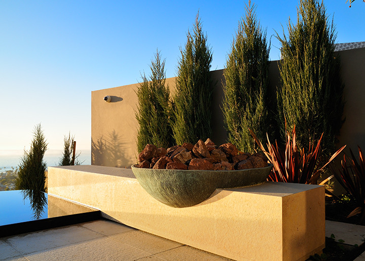 Großer Moderner Infinity-Pool hinter dem Haus in individueller Form mit Wasserspiel und Natursteinplatten in San Diego