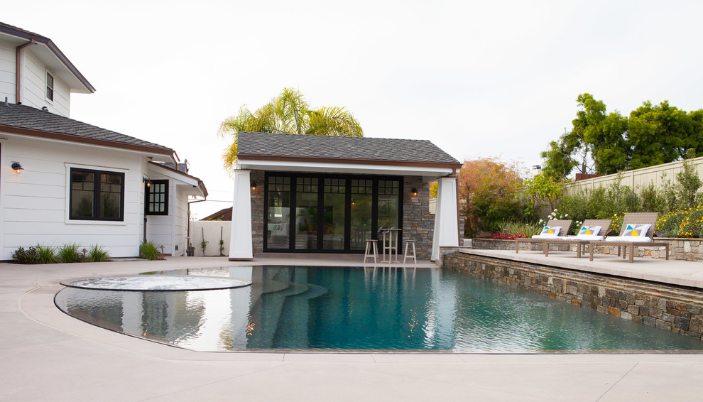 Diseño de casa de la piscina y piscina natural de estilo americano grande a medida en patio trasero con losas de hormigón