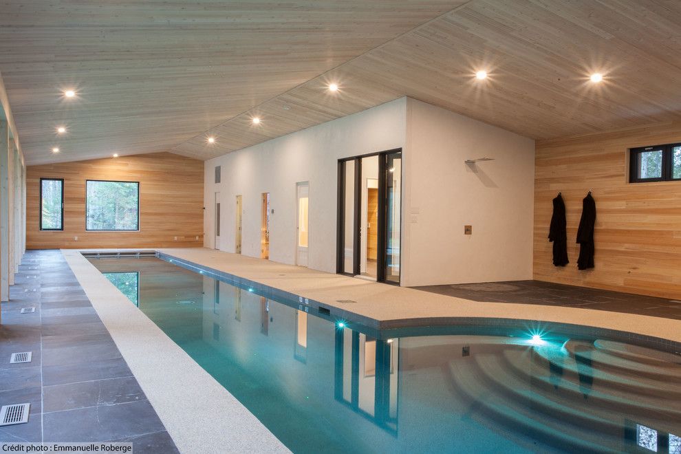 Imagen de piscina alargada actual grande interior y a medida con suelo de baldosas