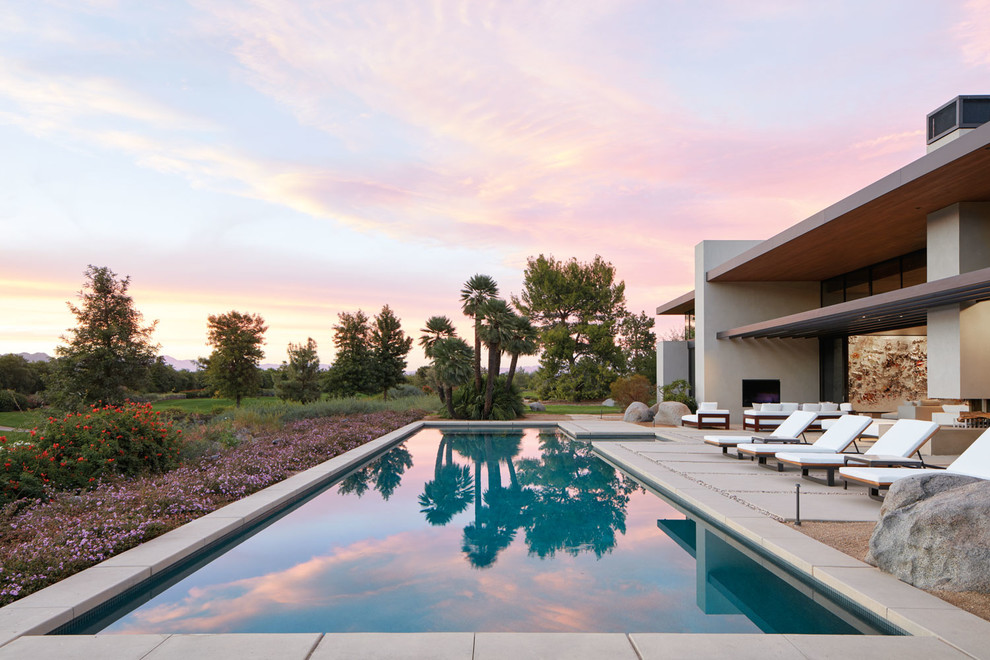 Großer Moderner Pool hinter dem Haus in rechteckiger Form mit Betonplatten in Sonstige
