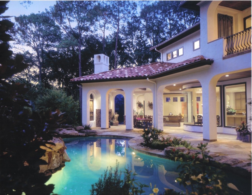 Large mediterranean back custom shaped swimming pool in Houston with natural stone paving.