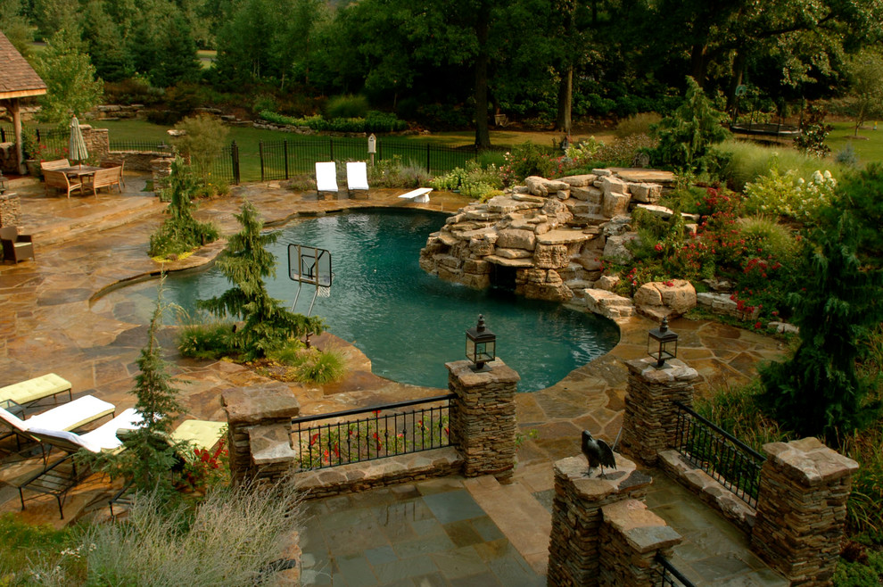 Idées déco pour une grande piscine naturelle et arrière craftsman sur mesure avec un bain bouillonnant et des pavés en pierre naturelle.