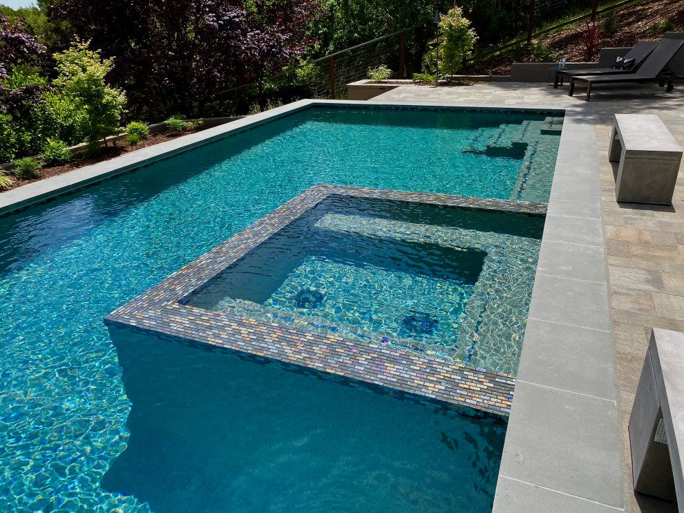 Idée de décoration pour une très grande piscine arrière minimaliste rectangle avec des pavés en béton.