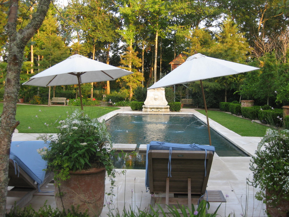 Exemple d'une piscine arrière et naturelle chic rectangle et de taille moyenne avec des pavés en pierre naturelle et un bain bouillonnant.
