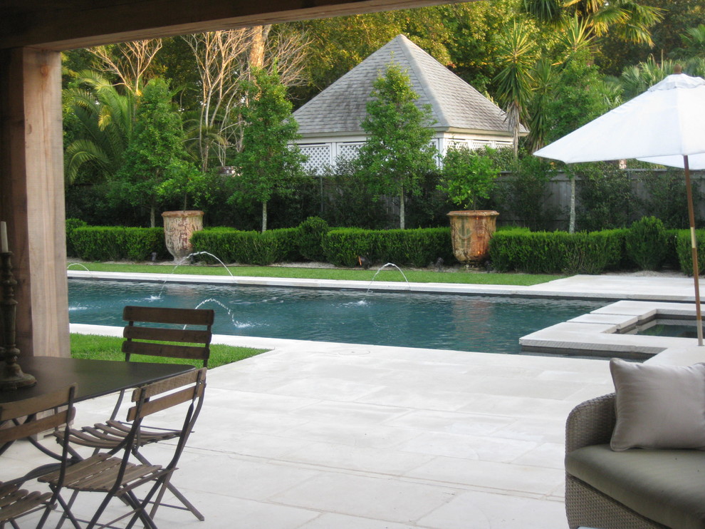 На фото: естественный, прямоугольный бассейн среднего размера на заднем дворе в стиле неоклассика (современная классика) с покрытием из каменной брусчатки и джакузи