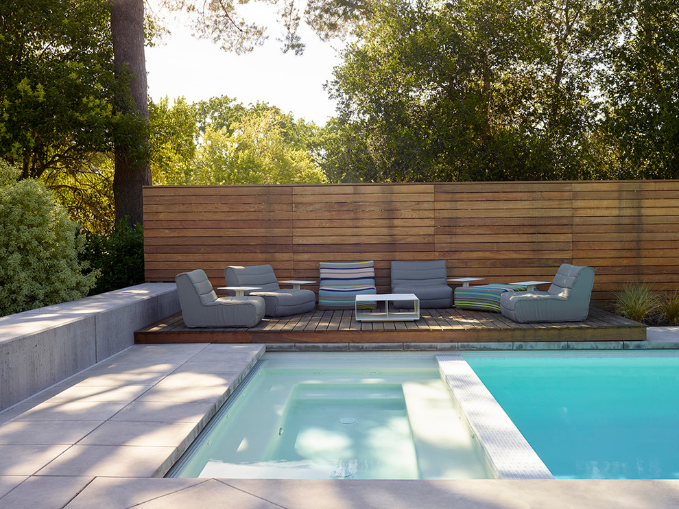 Inspiration pour une piscine arrière minimaliste rectangle avec un bain bouillonnant.